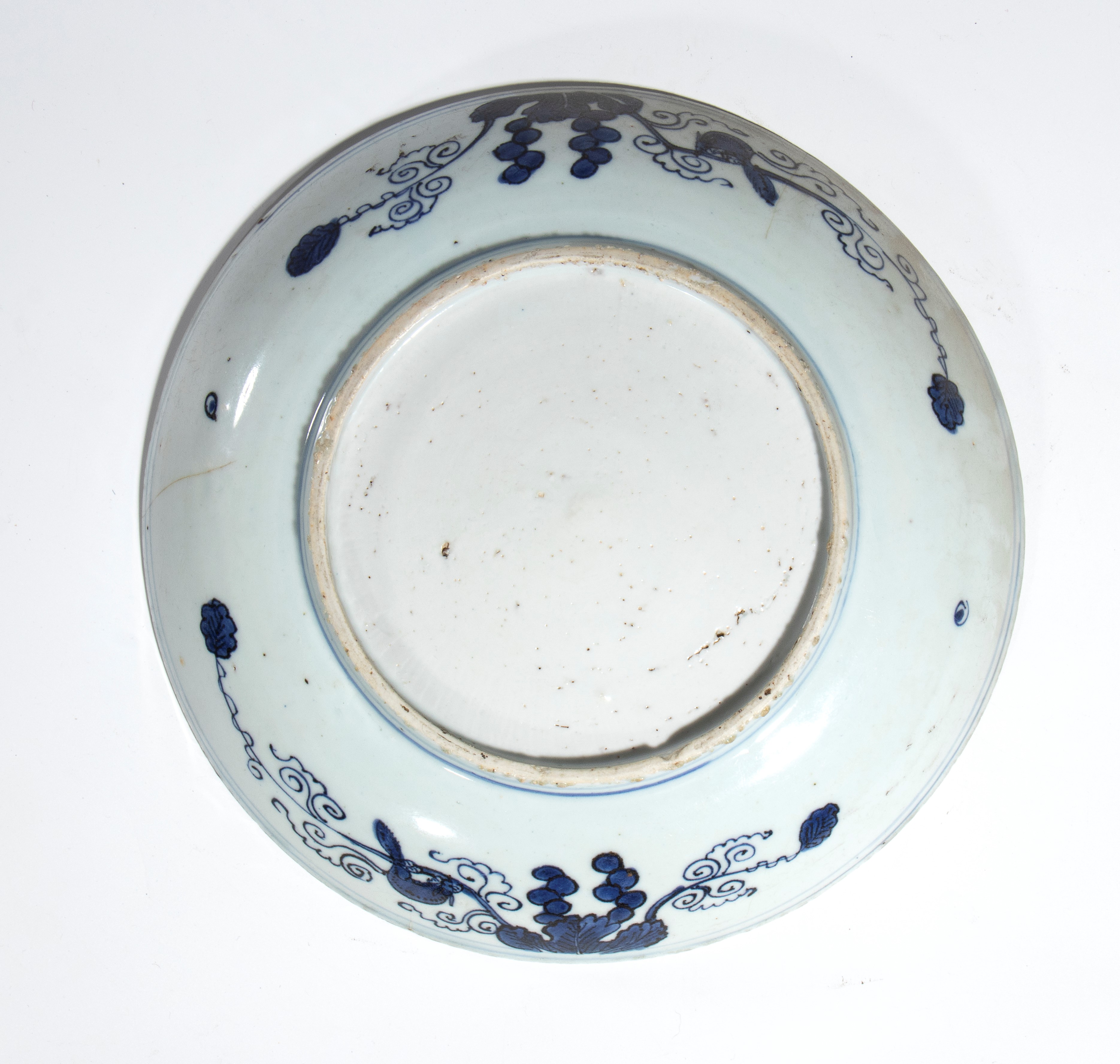 Cina, Piatto in porcellana Kraak bianca e blu con decorazione a fenici, rami e motivi floreali, d...