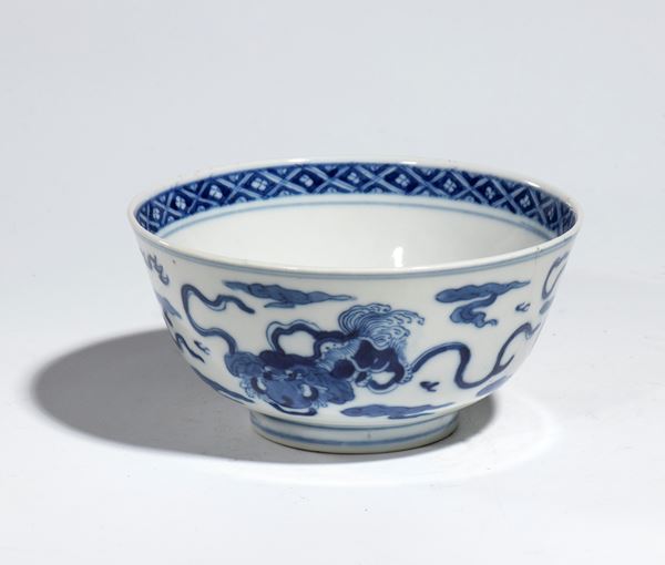 Ciotola in porcellana Kraak a decoro bianco e blu, con draghi. Al centro motivi floreali con bordo a reticolo e losanghe. Cina, Dinastia Ming, XVII secolo
