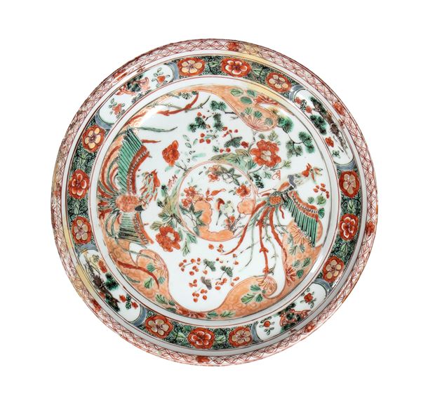 A green-enamel porcelain plate decorated with stylized phoenixes among flowering branches and floral medallions. China, Qing Dynasty, Kangxi period.