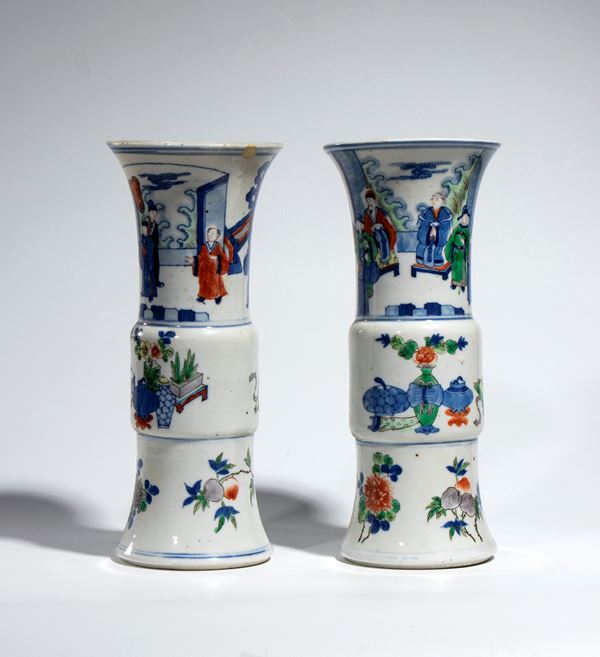 A pair of trumpet-shaped gu vases in wucai porcelain with garden figures. China, Qing Dynasty, Kangxi period.