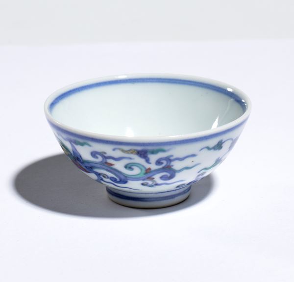 A small wucai porcelain sake bowl with polychrome and underglaze blue enamels depicting traditional dragon motifs. Japan, 19th-20th century.