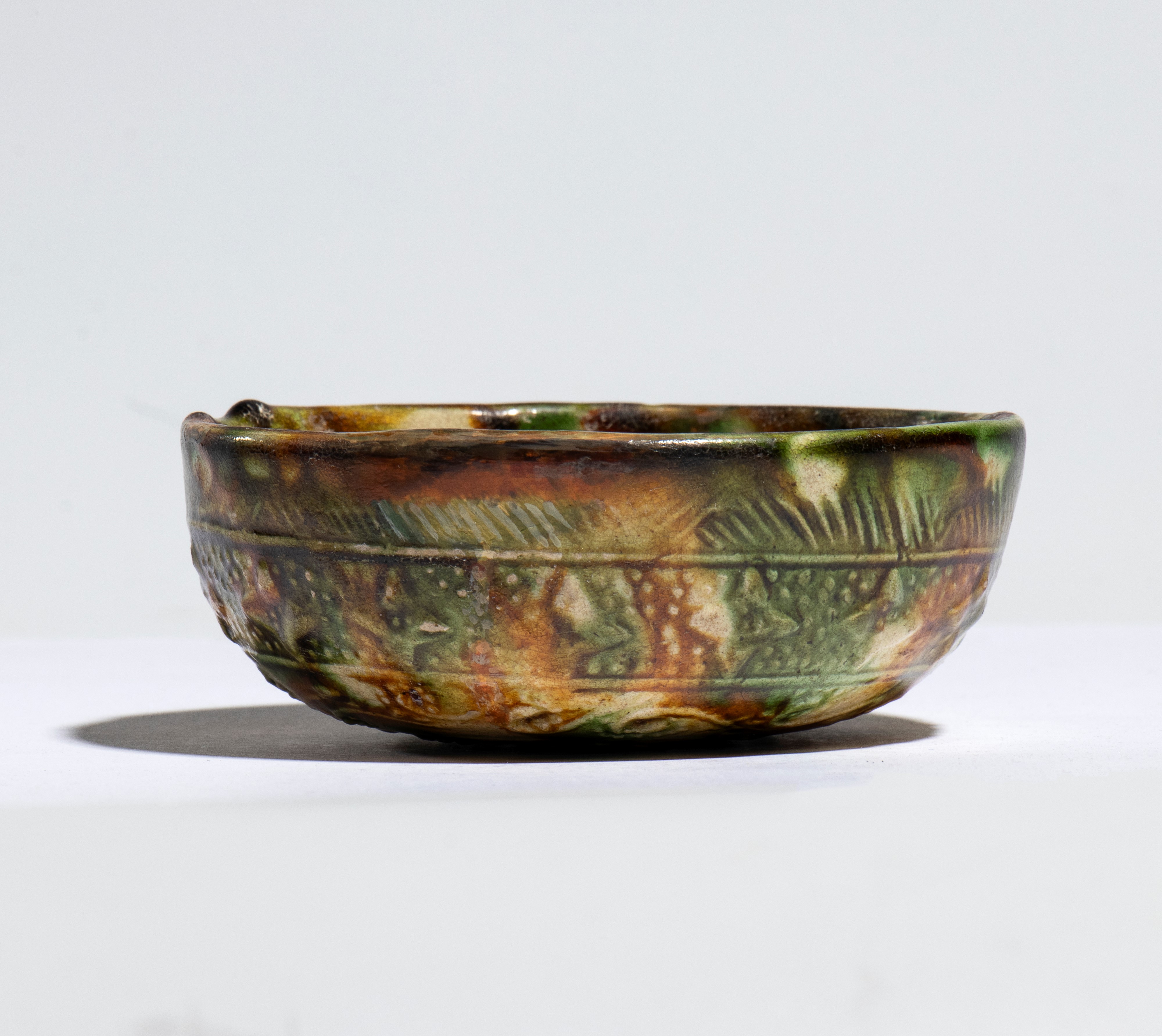 China, Dinastia Tang (VIII secolo), Ciotola in ceramica smaltata sancai con rilievi decorativi