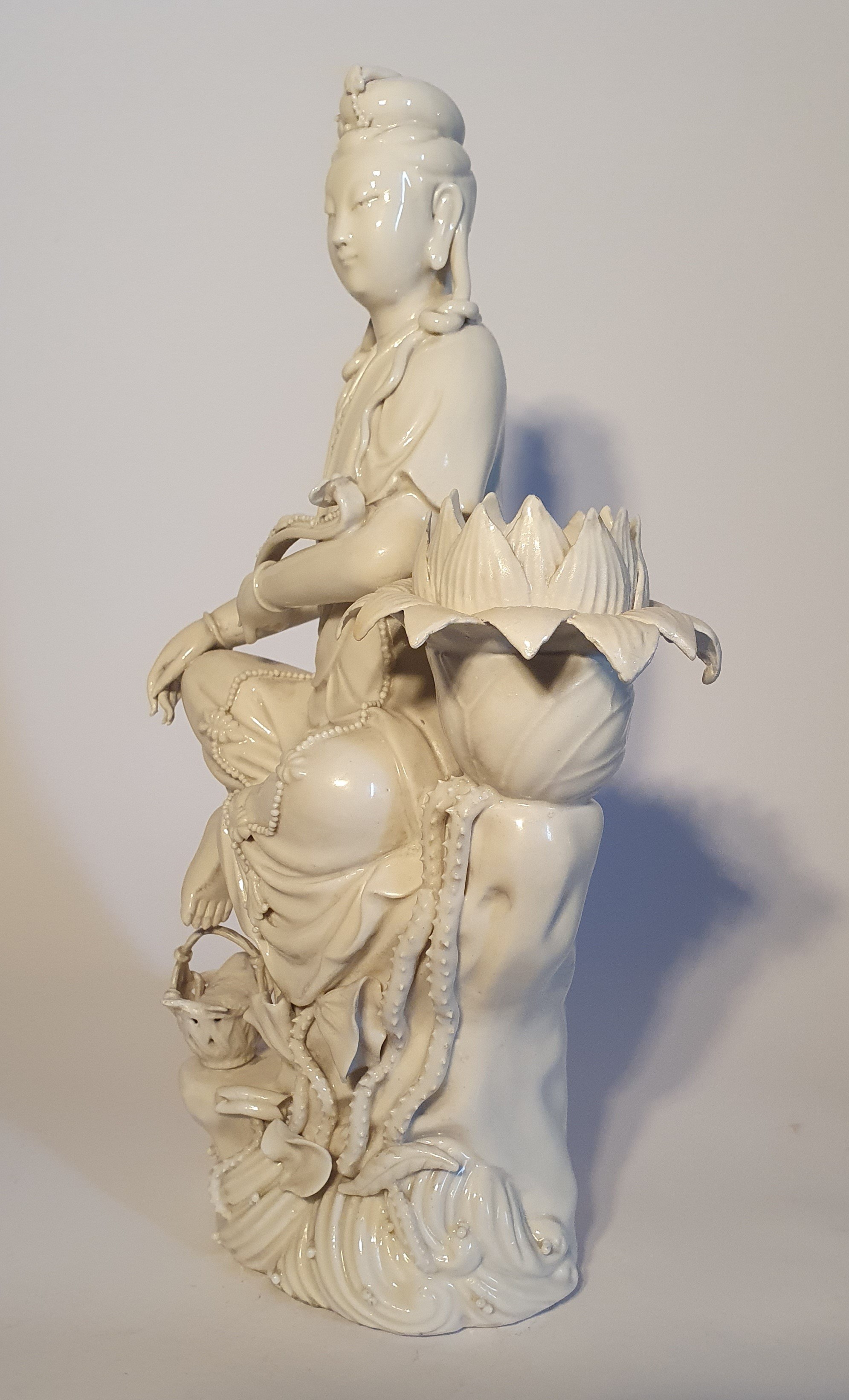 Statuetta in porcellana Dehua (Blanc de Chine), Bodhisattva seduto accanto a un fiore di loto