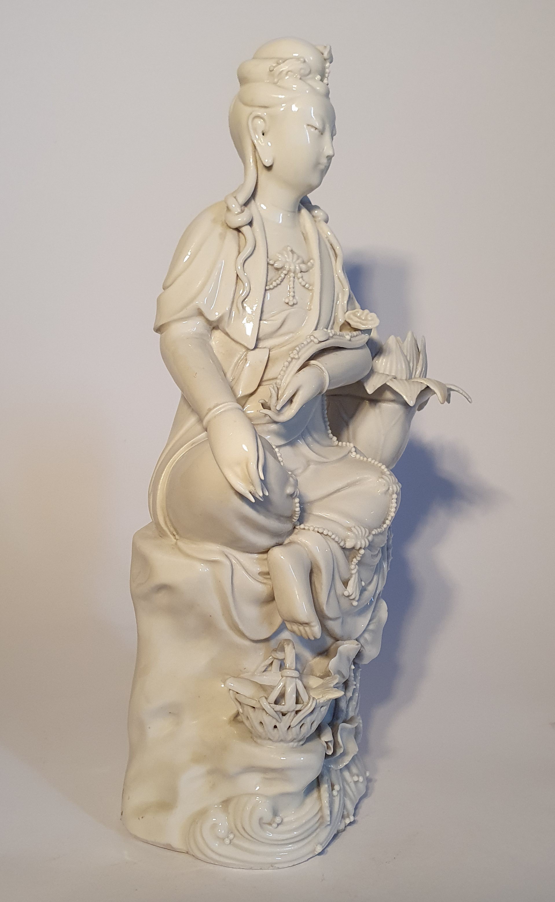 Statuetta in porcellana Dehua (Blanc de Chine), Bodhisattva seduto accanto a un fiore di loto