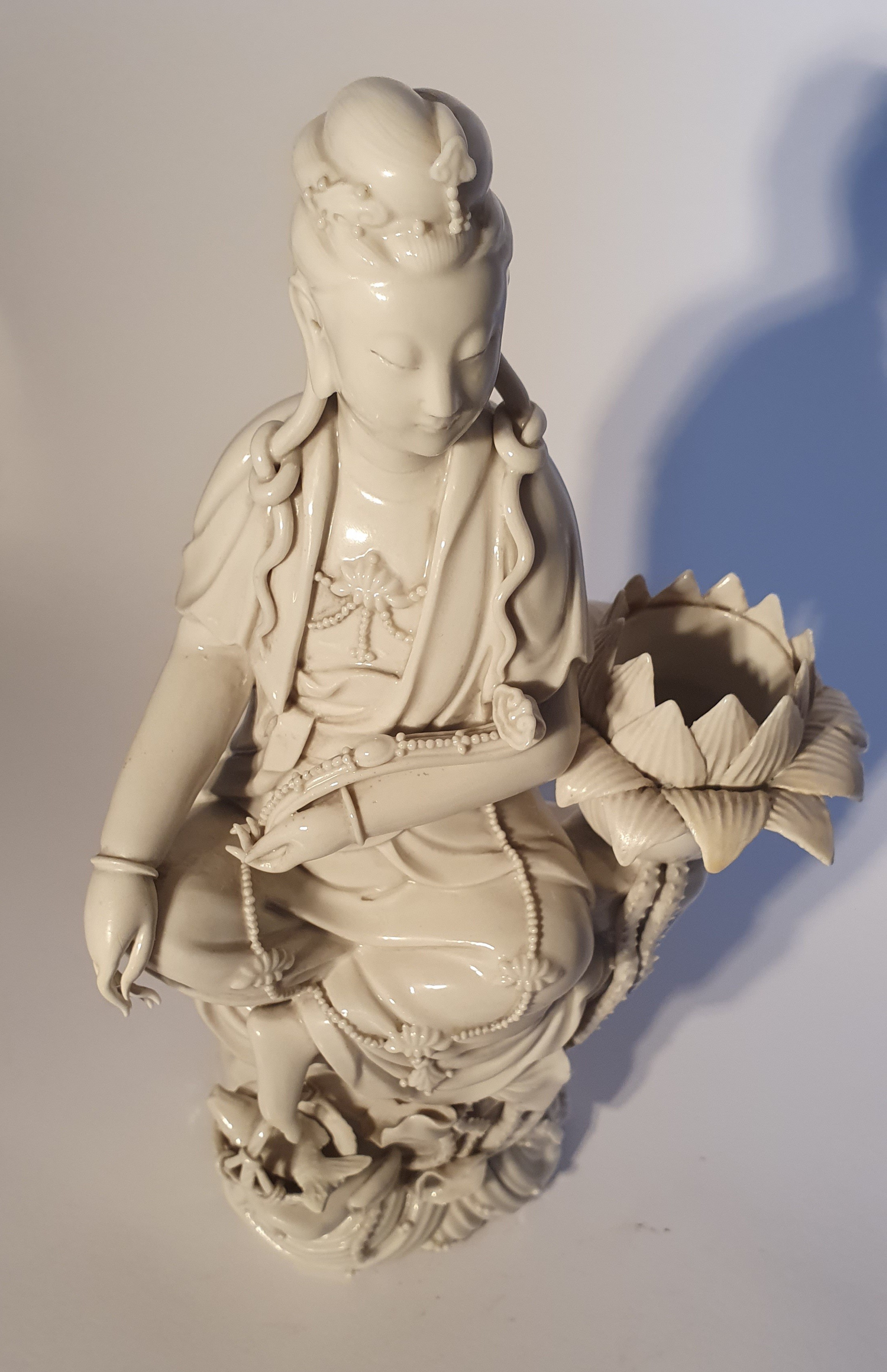 Statuetta in porcellana Dehua (Blanc de Chine), Bodhisattva seduto accanto a un fiore di loto