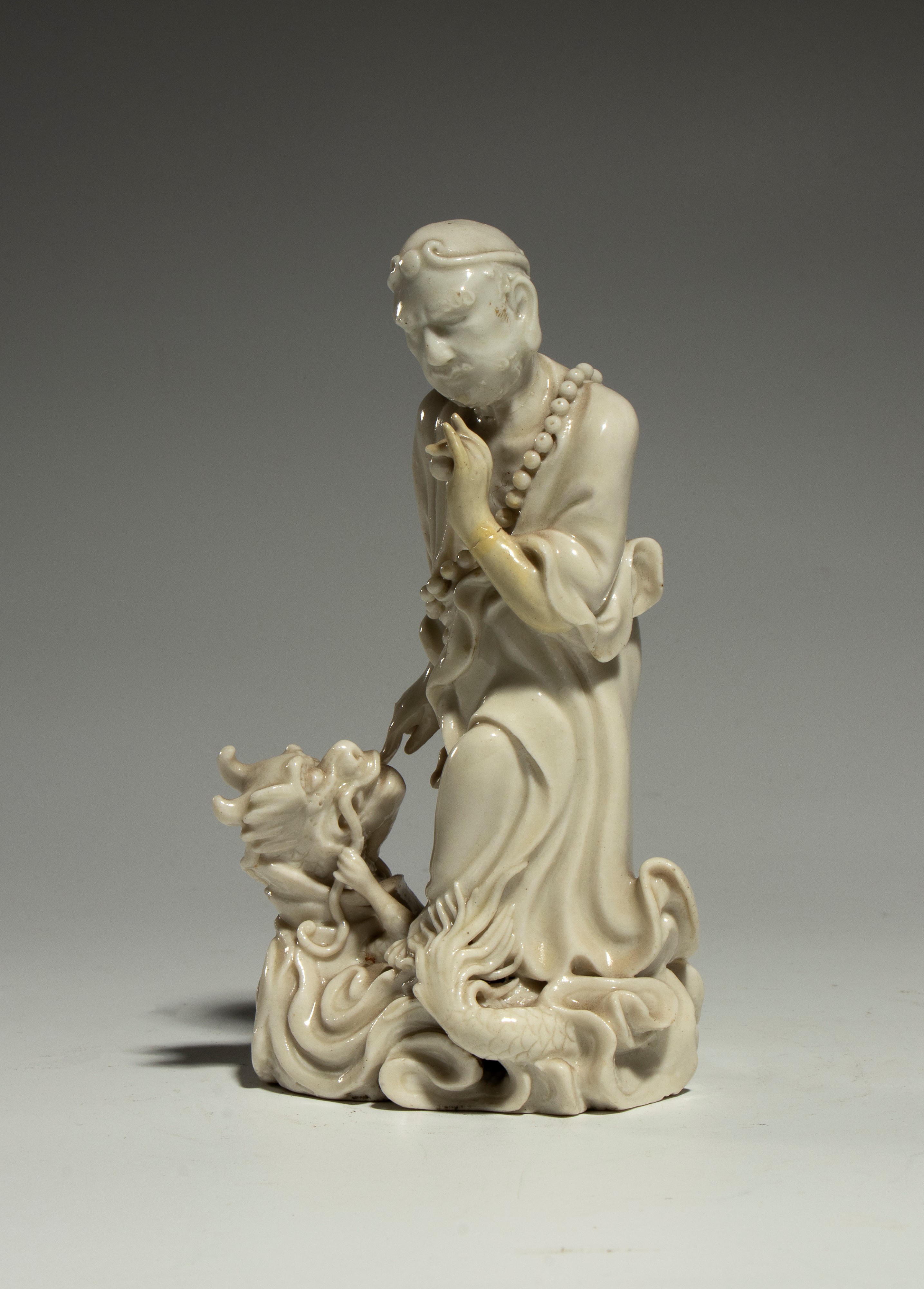 Figura in porcellana Dehua “Blanc de Chine”, Damo (Bodhidharma) in posa da “Vincitore del Drago” ...