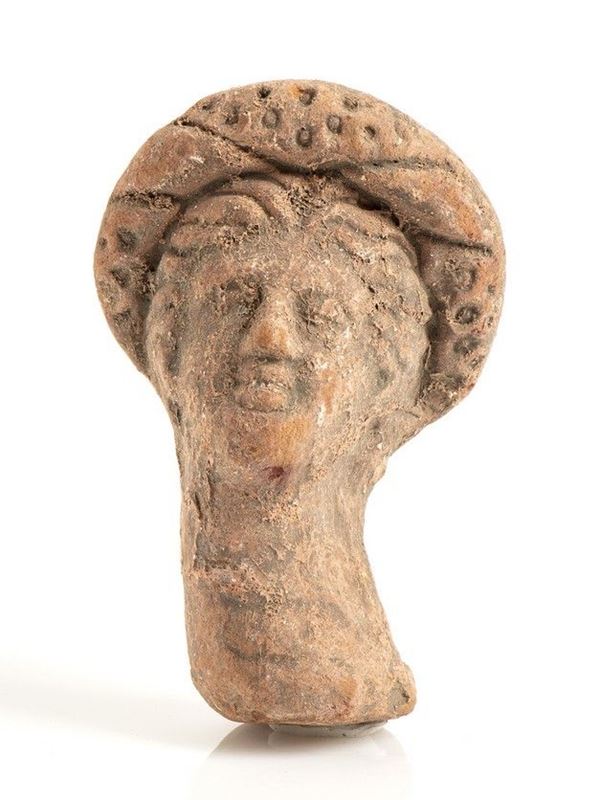 TESTA DI TANAGRINA DIADEMATA 
Epoca ellenistica
Terracotta, alt. cm 7,5, con st...