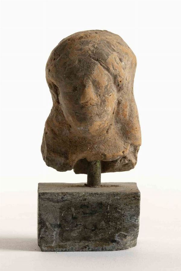 TESTA VOTIVA
Italia centrale, ca. III secolo a.C.
altezza testa cm 5; altezza t...